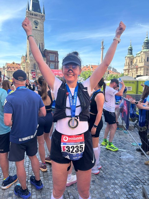 Pavla Pavelková v&nbsp;cíli Pražského maratonu s&nbsp;medailí a&nbsp;rukama nad hlavou